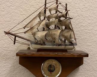 Vintage decorative nautical wall-hanging barometer featuring a wooden display shelf and an antique-style model clipper ship with fabric sails.