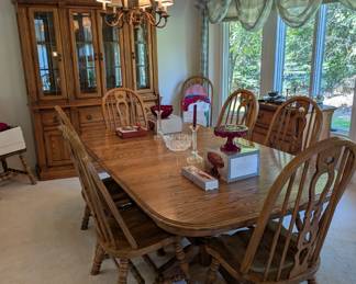 Oak dining room table with built in table leafs. There are eight chairs.