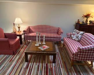 Matched set of single cushion couch and loveseat, skirted armchair, coffee and matching side table, and MCM stripped area rug, with decor