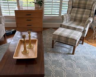 Another view of the coffee table with brass candle holder on wood tray, armchair and ottoman, and 4-drawer MCM Chest of drawers
