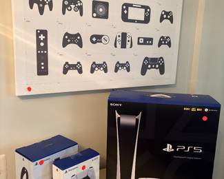 Another view of the PS5 console and controller in box, extra controller, headphones and decor