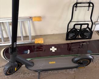 Segway Ninebot scooter with kickstand, snowboards and foldable handcart
