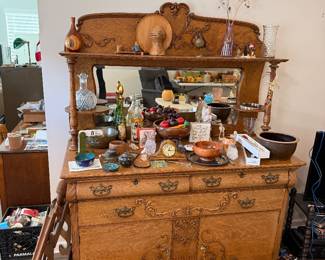 oak buffet featuring a beveled mirror back and ornate carvings
