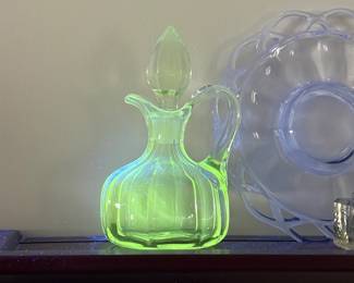 vintage glass cruet decanter with a stopper, glows bright under UV light