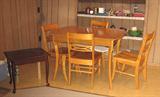 This is one of 3 dining room and kitchen table sets, all three wood with 4 wood chairs, located in this estate home.