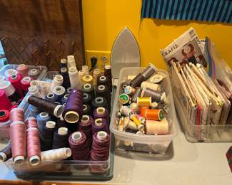 Serger thread, sewing thread, spools of quilting thread. Tons of dress, toy, and quilt patterns.