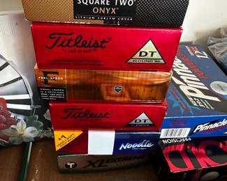 Lots of full boxes of brand new golf balls