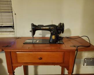 Singer sewing machine electric. Treadle style in basement.
