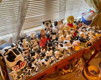 Cow figurines and cookie jars. Big Bird cookie jar. Table for sale.