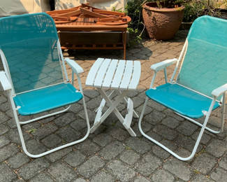 Lot 5: Outdoor patio furniture set: turquoise mesh chairs with white frames, a white folding table, and stacked white folding chairs