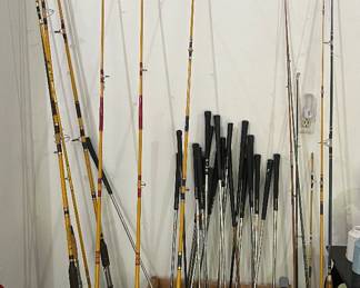 Numerous fishing rods and golf clubs.