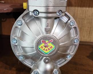 Rasm double diaphragm pump with a metallic housing, multiple bolts, and a central logo featuring a bird emblem