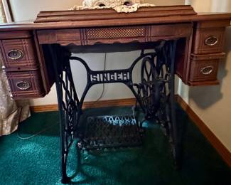 Antique Singer treadle sewing machine cabinet with antique Singer model 66 "Red Eye" or a Model 127/128 vibrating shuttle machine inside. (era 1910s-1920s) $125.
