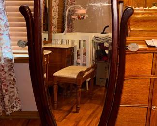 Powell Heirloom Cherry Cheval Mirror full-length floor mirror complemented by decorative dark metal scrollwork on base. Adjustable oval glass frame in rich cherry finish. Approx. 27w x 62h x 20d. $80.00