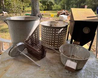 Left to Right and Front to Back: Aluminum Skimmer/strainer $10. Wire Mesh Deep Fryer Baskets. $10 each. Aluminum Basket with Wood Handles. $10.  Large Aluminum Boiling Pot. $40. Large Perforated Aluminum Strainer Basket $25.  