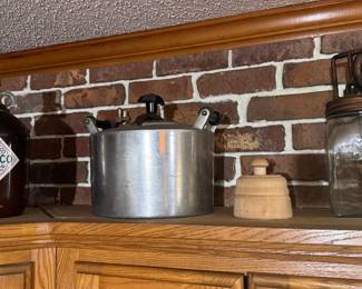 Left to Right: Vintage Tabasco Brand Pepper Sauce 1-Gallon Glass Jug. $25. Vintage National Pressure Cooker Co. No. 7 Canner Pot. $40. Vintage Turned Wooden Butter Mold. $20. Vintage Dazey No. 40 4-Quart Glass Hand-Crank Butter Churn. $80.