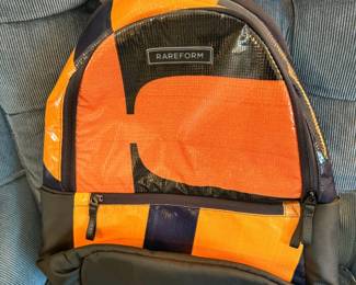 A Rareform Everyday Backpack crafted from sustainably repurposed billboard vinyl, featuring a unique orange and black abstract patchwork pattern.