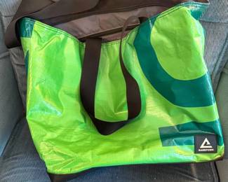 A green graphic Rareform Blake tote bag features durable black shoulder straps and a unique, water-resistant exterior crafted from repurposed billboard vinyl.
