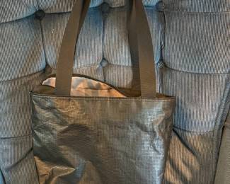 This Rareform Zippered Blake Tote features a durable textured black exterior crafted from repurposed billboard vinyl.