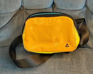 This unique one-of-a-kind Rareform Zion sling bag features a vibrant textured yellow and orange repurposed billboard vinyl exterior.