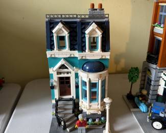 This section of the LEGO Creator Expert Bookshop (Set #10270) set features the teal and dark blue residential townhouse building with an elevated front porch, bay window and mansard roof.