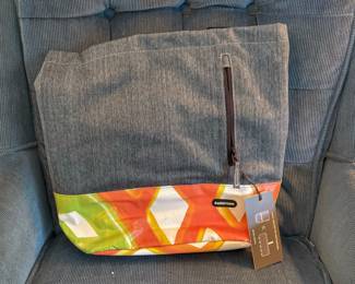 The gray heathered and colorful patterned billboard vinyl Rareform Cora Tote features an extra-wide opening and a vertical front zip pocket