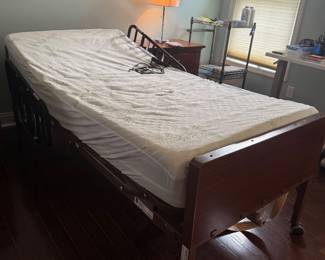 Adjusting hospital bed by Medline. Has bed topper and mattress cover 