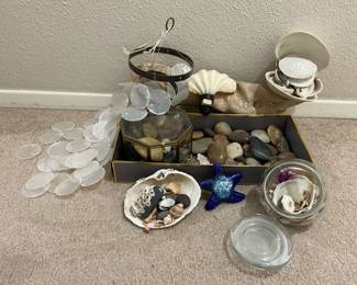 Collection Of Polished Rocks With Seashells A Driftwood Piece Capiz Shell Wind Chime