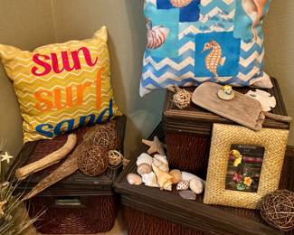 Three decorative baskets, beachy pillows, shells, and picture frames
