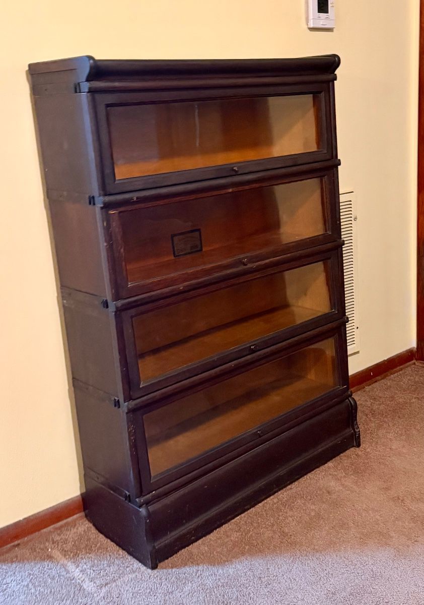 Globe-Wernicke barrister bookcase with original manufacturer labels. This piece has been researched for identification, style, and current market comparisons. A distinctive antique stacking bookcase with glass-front sections and strong collector appeal.
