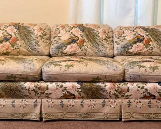 Vintage floral upholstered sofa with three seat cushions, rolled arms, tailored skirt, and coordinating patterned fabric. Generous full-size seating with classic traditional styling. There is visible cat-scratch damage to the upholstery on both the left and right arms; please review photos carefully. Condition is reflected in the pricing.