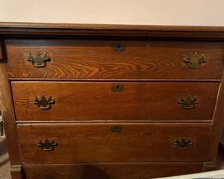 Antique oak cottage chest of drawers with three full-width drawers, pronounced oak grain, traditional brass-tone bail pulls, and keyhole escutcheons. Classic 19th-century-style construction and proportions with a warm aged finish. Researched prior to sale.