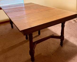 Vintage Jacobean-style solid wood dining table with three removable extension leaves, expanding to nearly 7 feet long. Features turned legs, stretcher base, and casters. The three leaves were rarely/never used and retain a darker original finish than the main tabletop. Researched prior to sale.