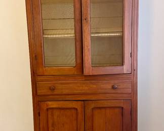 Vintage solid wood screen-front cabinet with upper shelving, center drawer, and lower cabinet storage. Warm wood finish with a classic country/primitive furniture look. Researched prior to sale.