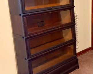 Globe-Wernicke barrister bookcase with original manufacturer labels. This piece has been researched for identification, style, and current market comparisons. A distinctive antique stacking bookcase with glass-front sections and strong collector appeal.