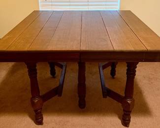 Vintage Jacobean-style solid wood dining table with three removable extension leaves, expanding to nearly 7 feet long. Features turned legs, stretcher base, and casters. The three leaves were rarely/never used and retain a darker original finish than the main tabletop. Researched prior to sale.