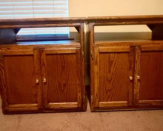 Matching pair of vintage oak storage cabinets with open upper shelves and double-door lower storage. Strong visible oak grain, paneled doors, and traditional styling. Versatile pieces for media, books, collectibles, or general storage. Researched prior to sale.