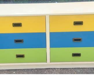 Vintage campaign-style six-drawer dresser with colorful yellow, blue, and green drawer fronts, recessed metal pulls, and metal corner accents. Fun retro piece with plenty of storage. Researched prior to sale.