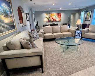 Stylish leather sofas, chairs, glass coffee table and artwork (artwork in center of this picture is not for sale)
