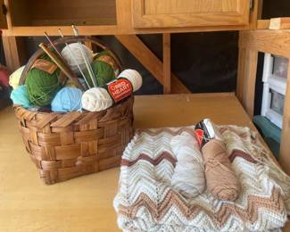 Knitting Needs With Basket Of Yarn And Almost Finished Blanket