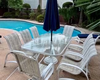 263. Dining Set from Fortunoff Wavy Glass Top Table on Aluminum Base (42.5" x 70.5" x 28") w/ 8 Chairs 2 Swivel Arm and 6 Side and Umbrella