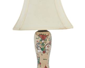 1338 A Japanese crackle glaze ceramic vase as a lamp 20th century Wood base impressed: HONOKOMO The vase painted with warrior figures, issuing two Leviton lights and raised on a carved wood base, surmounted by a fabric shade, electrified Lamp height 22 3/4 in., diameter 4 1/2 in.; vase height 11 1/2 in.; height of shade 10 5/8 in., width 14 1/4 in., depth 10 1/8 in. Estimate: $100 - $150