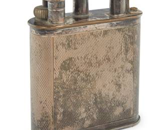 1143 A Dunhill silver plated table lighter Early 20th century Marked for maker and: MADE IN ENGLAND Height 4 1/4 in., width 3 1/4 in., depth 1 1/8 in. Estimate: $300 - $500