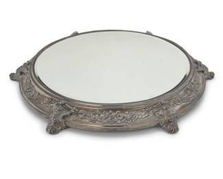 1172 A Continental silver plated mirrored plateau Early 20th century With floral garlands, raised on scrolling cartouche feet Height 2 in., diameter 19 3/4 in.; diameter of glass 14 1/2 in. Estimate: $300 - $500