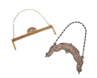 1323 Two vintage purse frames Two works: Late 19th century A Gorham sterling silver repoussé purse frame featuring multiple putti and floral scrollwork motifs and a daisy-chain handle Marked to interior edge near hinge for Gorham, Birmingham UK, Sterling; further marked: 2392 Height 5 in., width 7 3/8 in., depth 3/8 in., handle drop 6 1/4 in. Early/mid-20th century A gilt metal Trinity Plate purse frame with filigree motifs and set blue diamanté stones with a paperclip chain handle Marked to interior edge: Trinity Plate Height 3 5/8 in., width 9 1/8 in., depth 1/2 in.; handle drop 7 in. 2 pieces Weighable silver 8.77 oz. troy Estimate: $250 - $350