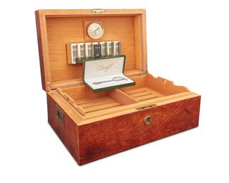 1235 A Daniel Moevus humidor and Davidoff cigar cutter Early 21st century Each marked for maker The humidor with burlwood veneer, inlaid accents, and locking lid, housing a Credo Precision 70 humidifier, and a Davidoff chromed cigar cutter in original formed box 2 pieces Humidor height 7 3/4 in., width 18 in., depth 12 in.; length of cutter 5 3/4 in. Estimate: $300 - $500