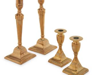 1047 Two pairs of Georgian brass candlesticks 18th/early 19th century Comprising a taller pair and a lower pair, each with flared urn-form nozzle and square base 4 pieces Taller height 9 1/2 in; shorter height 5 in. Estimate: $300 - $500