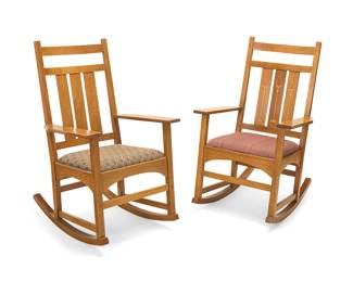 1074 Two Stickley quarter sawn oak rocking chairs, no. 35 1993 & 1997 Each with factory burn mark and applied metal Mission Reissue label; additionally stamped with date and: # 35 With slatted backs above upholstered seat cushions, the legs joined by a box stretcher and raised on rockers, one seatback inlaid with design by Harvey Ellis (1852-1904) 2 pieces Height of each 41 1/2 in., width 24 3/4 in., depth 31 in. Estimate: $400 - $600