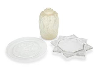 1134 A René Lalique glass 'Fauvettes' ashtray and 'Sirenes' atomizer 20th century Ashtray etched: R. Lalique; atomizer with molded stencil mark: R. LALIQUE; and etched: Lalique; plate etched: Lalique France Together with a later Lalique 'Olympe' bread & butter/dessert plate 3 pieces Ashtray diameter 6 7/8 in.; atomizer height 5 1/2 in., diameter 3 5/8 in.; plate diameter 6 1/2 in. Estimate: $500 - $700