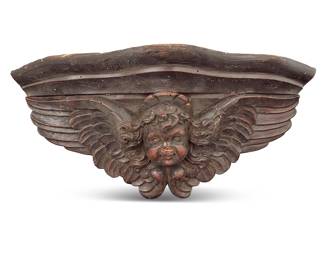1115 A Continental carved wood wall bracket Early 20th century Depicting a winged putti mask in relief Height 7 1/2 in., width 17 3/4 in., depth 7 1/2 in. Estimate: $400 - $600